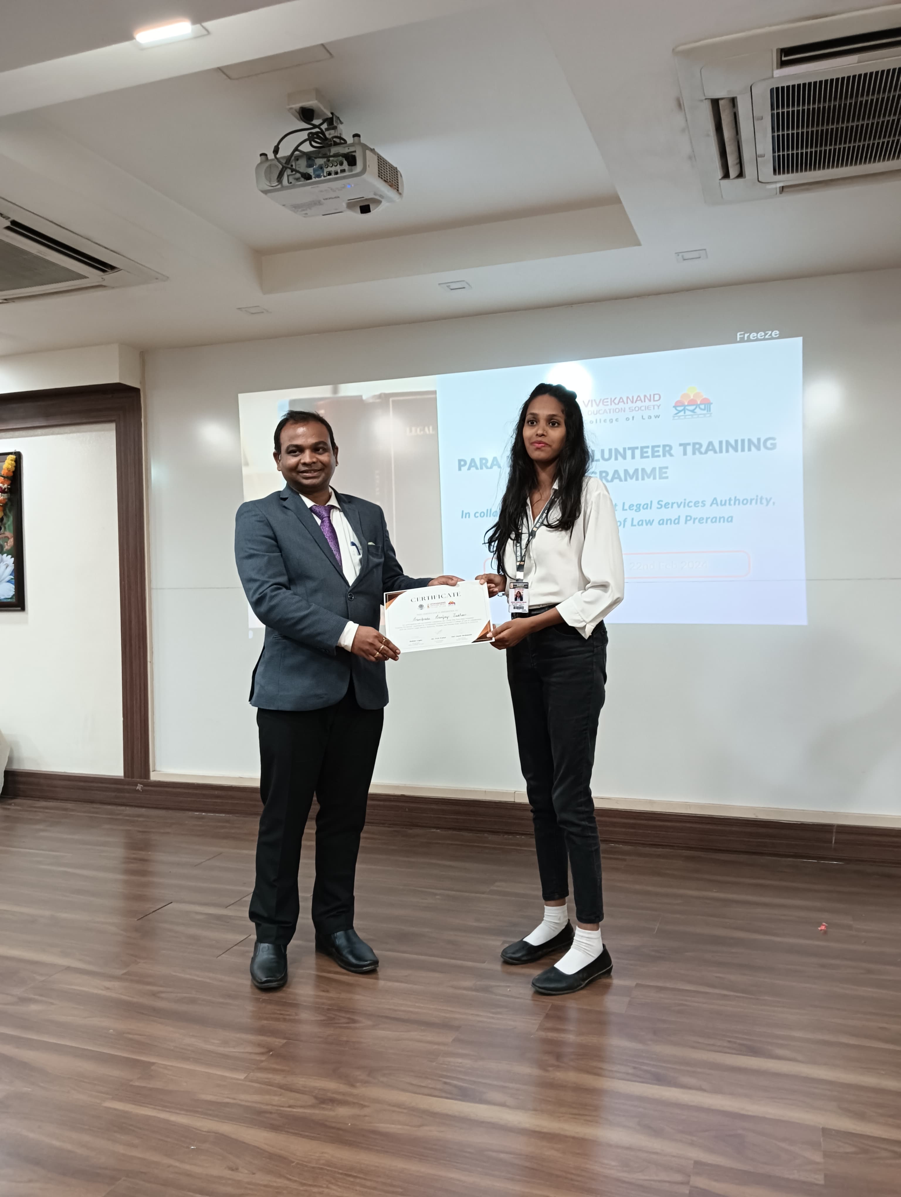 Dr. Choudhary presenting PLV certificate to female law student volunteer